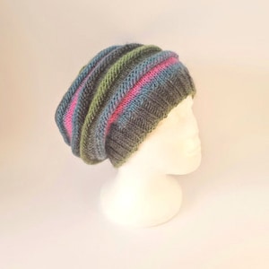 May include: A slouchy beanie hat with a striped pattern in shades of green, blue, pink, and gray.
