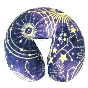May include: A purple and yellow travel neck pillow with a celestial pattern of stars and moons.