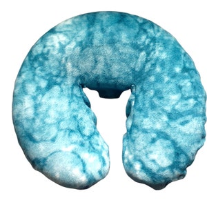 May include: A blue and white tie-dye patterned neck pillow for massage therapy.