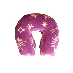 May include: Purple neck pillow with a white moon and star pattern.
