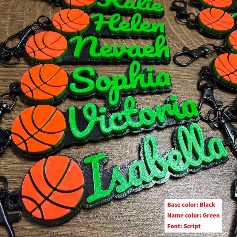 May include: Custom basketball keychains with names in green script font. Each keychain features a black base and an orange and black basketball design. The names include Helen, Nevaeh, Sophia, Victoria, and Isabella.