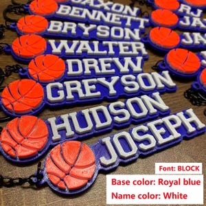 May include: Keychains with names in white block letters on a royal blue base, each with an orange basketball design. The image includes names like "Bryson", "Walter", and "Joseph". The font is BLOCK.