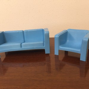 May include: A set of two blue plastic toy furniture pieces, a couch and a chair. The couch has two seats and the chair has one seat.