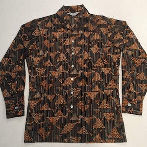 May include: A long-sleeved shirt with a geometric pattern in shades of orange and brown on a black background.