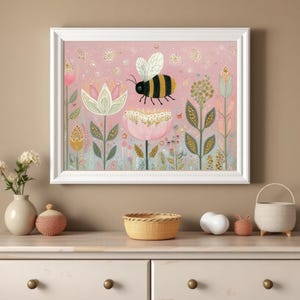 Pu&ograve; includere: Una stampa artistica incorniciata con un'illustrazione di un'ape sopra fiori stilizzati. L'opera d'arte ha uno sfondo rosa tenue con dettagli dorati e una cornice bianca. L'ape &egrave; nera e gialla.