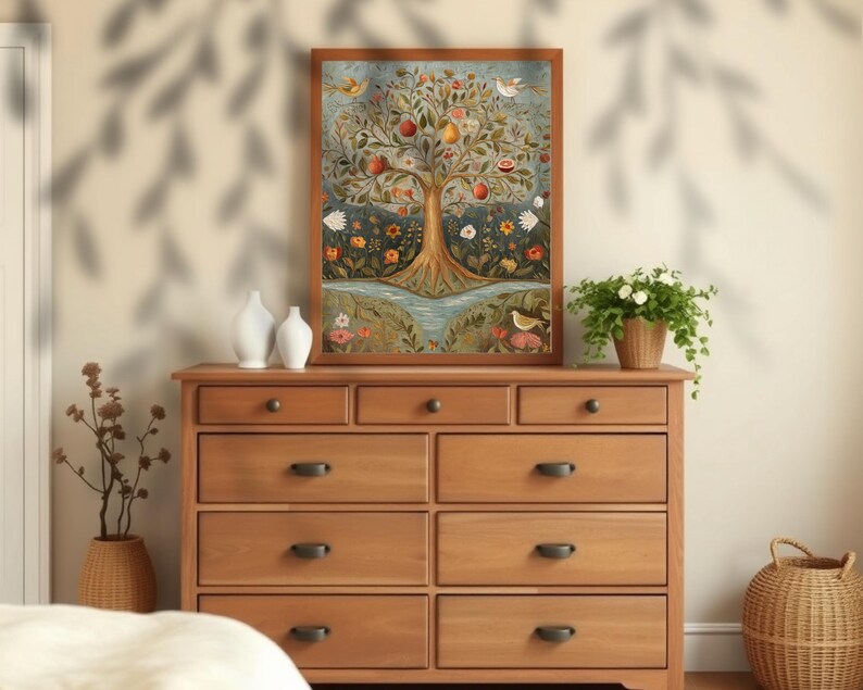 May include: A framed painting depicting a stylised tree laden with colourful fruits, flowers and birds. The tree is set against a blue background with a river flowing beneath it. The painting is displayed on a wooden dresser with other decorative items.