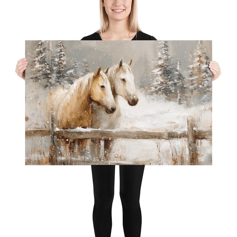 May include: A framed art print featuring two horses in a snowy landscape. One horse is a light tan color, and the other is white. They stand behind a wooden fence, with snow-covered trees in the background.