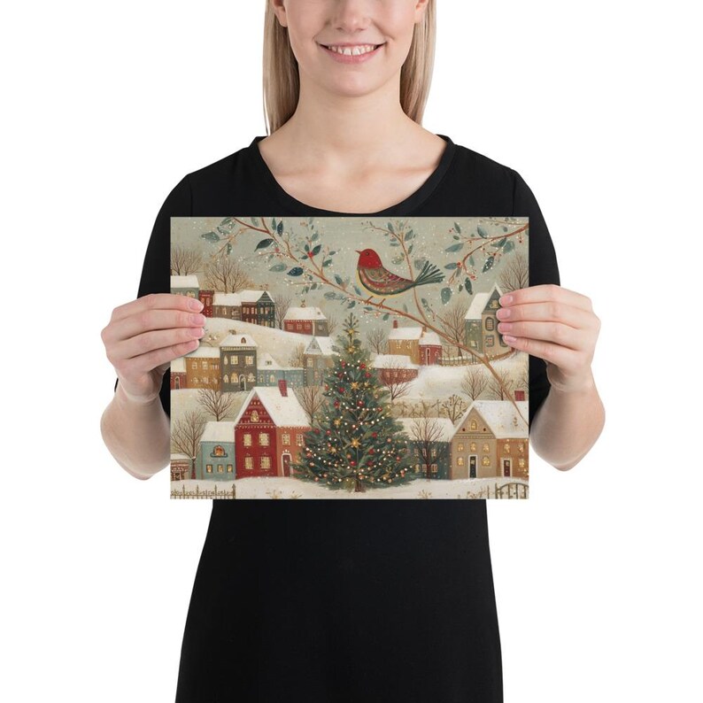 May include: A rectangular print featuring a winter village scene with snow-covered houses, a central decorated Christmas tree, and a red bird perched on a branch above. The illustration uses a muted colour palette of soft blues, reds, and browns.