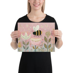 Pu&ograve; includere: Una stampa rosa con un'ape stravagante a strisce nere e gialle, sospesa sopra un fiore rosa e bianco. L'opera d'arte include fiori e fogliame stilizzati in colori tenui, creando una scena onirica ispirata alla natura.