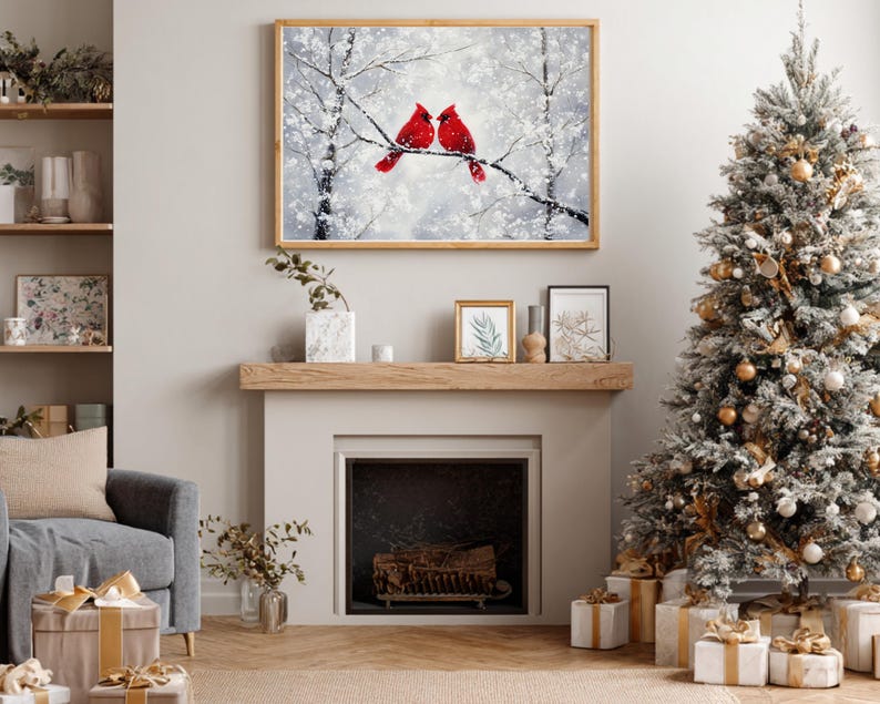 May include: A framed winter landscape painting featuring two vibrant red cardinals perched on a snow-covered branch. The artwork hangs above a fireplace, complemented by a decorated Christmas tree and wrapped gifts, creating a festive holiday scene.