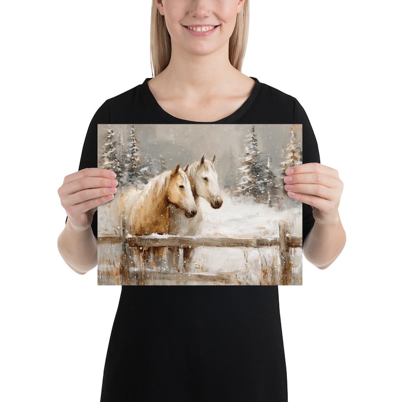 May include: A print featuring two horses in a snowy landscape. The horses, one tan and one white, stand behind a wooden fence. Evergreen trees and falling snow complete the winter scene.