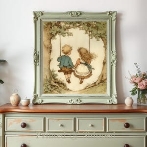May include: A framed print depicts two children on a swing, set against a backdrop of a tree. The artwork features soft colors and a vintage aesthetic. The frame is a light green with ornate detailing. The print is displayed on a light green dresser.