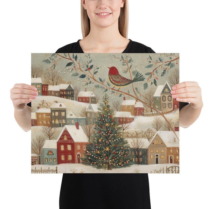 May include: A square art print featuring a winter village scene with snow-covered houses, a central decorated Christmas tree with lights, and a red bird perched on a branch in the foreground. The illustration uses a muted colour palette of red, green, and white to depict a festive holiday landscape with soft, snowy textures throughout the entire composition.