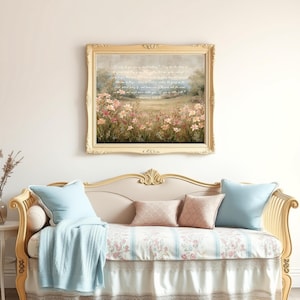 May include: A framed landscape painting with a gold ornate frame hangs above a cream-colored chaise lounge. The painting depicts a field of pink flowers. The chaise lounge has light blue pillows and a matching throw.