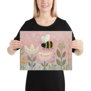 Pu&ograve; includere: Un poster rosa con un'illustrazione stravagante di un'ape che vola sopra fiori stilizzati. L'ape ha strisce nere e gialle e i fiori sono in tonalit&agrave; di rosa, bianco e oro. Lo sfondo &egrave; rosa tenue.