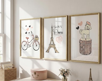 Può includere: Tre stampe artistiche incorniciate con cornici dorate. Le stampe presentano illustrazioni di una bicicletta, della Torre Eiffel con la scritta "Take Me To Paris" e di un barboncino. L'opera d'arte ha uno schema di colori rosa e nero.