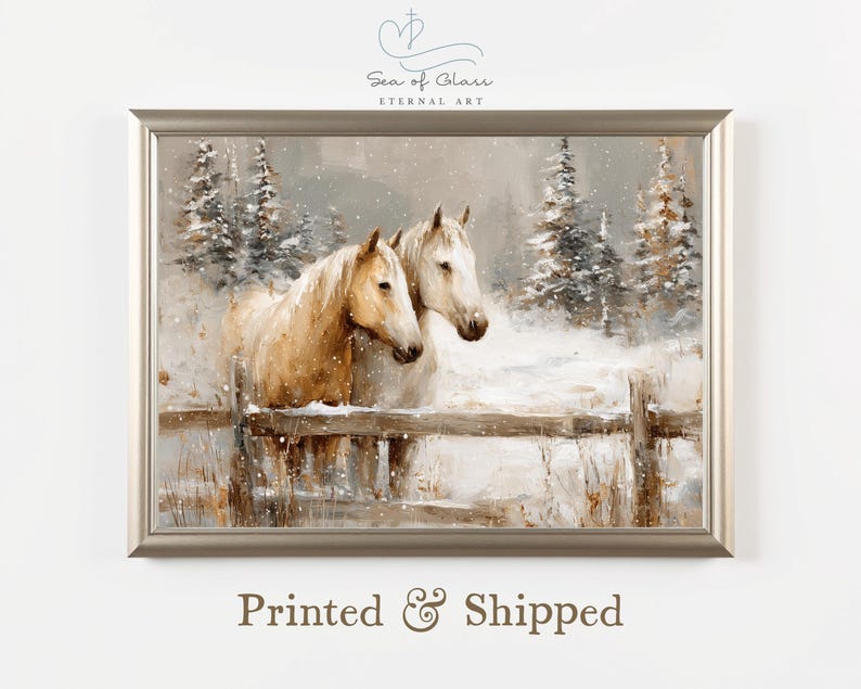 May include: A framed art print depicts two white and tan horses in a snowy landscape. The horses stand near a wooden fence, with snow-covered pine trees in the background. The artwork has a soft, painterly style.