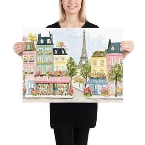 May include: A colorful print of a Parisian street scene featuring buildings in shades of pink, yellow, and green. The Eiffel Tower is visible in the background. The print has a light blue sky and is decorated with flowers.