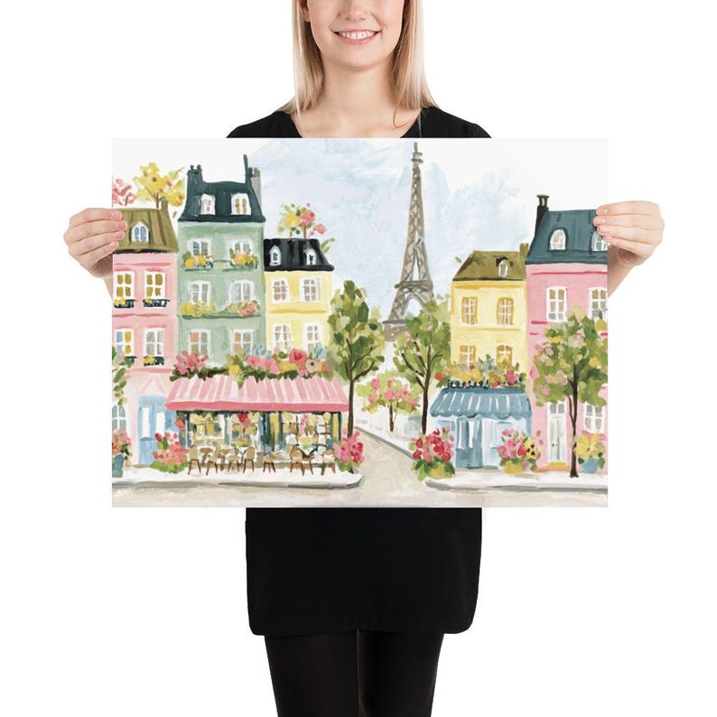 May include: A colorful print of a Parisian street scene featuring buildings in shades of pink, yellow, and green. The Eiffel Tower is visible in the background. The print has a light blue sky and is decorated with flowers.