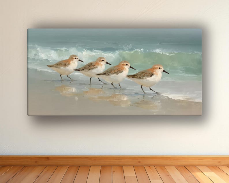 May include: A canvas print depicts four sandpipers walking along a sandy beach with gentle waves in the background. The birds have brown and white feathers, and the ocean is a mix of blue and green.