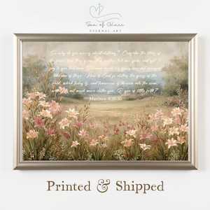 May include: A framed print featuring a pastoral scene with wildflowers and a quote from Matthew 6:28-30. The artwork has a soft, muted color palette with text that reads "Printed & Shipped". The frame is a neutral color.