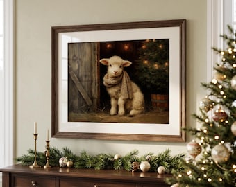 May include: A framed wall art print featuring a fluffy white lamb wearing a beige knit scarf, sitting in a rustic wooden barn next to a small Christmas tree with warm glowing lights, displayed above a dark wood console table.
