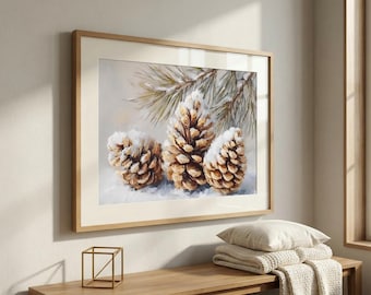 May include: A framed wall art print featuring a painting of three brown pinecones dusted with white snow, positioned beneath a pine branch with green needles. The artwork is encased in a light-colored wooden frame with a wide white mat border.
