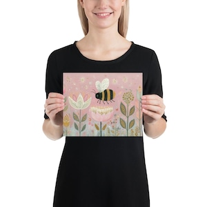 Pu&ograve; includere: Una stampa rosa raffigurante un'ape che vola sopra i fiori. L'ape ha strisce nere e gialle e ali bianche. I fiori sono bianchi, rosa e gialli, con steli e foglie verdi. Lo sfondo &egrave; rosa chiaro con piccoli punti bianchi.