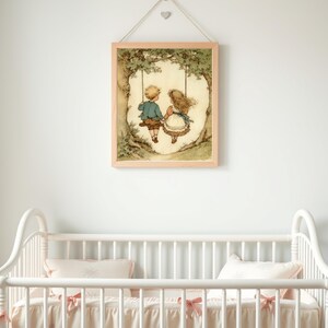 May include: A framed print of two children on a swing, set against a backdrop of a tree. The artwork features soft colors and a vintage aesthetic. The print is displayed above a white crib with pink bows.