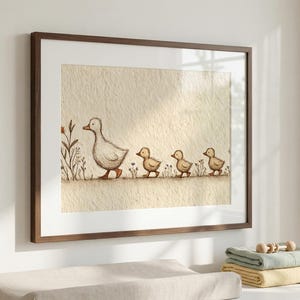 May include: Watercolor print of a mother duck and three ducklings walking in a line. The artwork is framed in a brown wooden frame and has a neutral color palette. The print is a charming addition to a nursery or child's room.