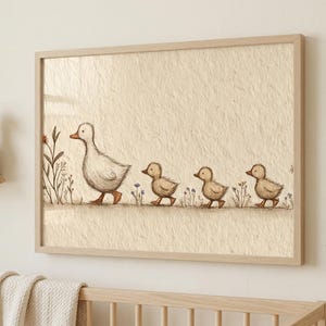 May include: A framed print featuring a mother duck and three ducklings walking in a line. The illustration is in soft brown and beige tones, with delicate floral accents. The artwork is displayed in a light wooden frame.
