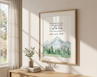 May include: A framed art print featuring a watercolor painting of mountains and trees in shades of green and blue. The text reads: "THE MOUNTAINS AND HILLS MAY CRUMBLE, BUT MY LOVE FOR YOU WILL NEVER END, Isaiah 54:10."