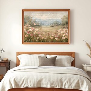 May include: A framed artwork featuring a pastoral scene with pink and white flowers in a field. The artwork has a wooden frame and includes text from Matthew 6:28-30. The artwork is displayed above a bed with a wooden headboard.