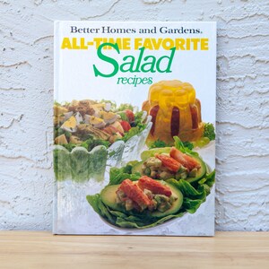 May include: A cookbook titled "Better Homes and Gardens All-Time Favorite Salad recipes" with a white background and colorful photos of salads on the cover.