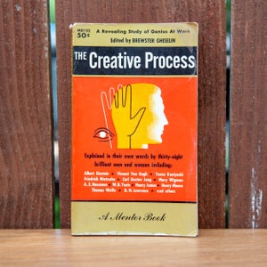 May include: A vintage paperback book titled "The Creative Process: A Revealing Study of Genius At Work" with a yellow, orange, and black cover featuring a stylized hand and eye. The book is edited by Brewster Ghiselin and includes contributions from Albert Einstein, Vincent Van Gogh, and others.
