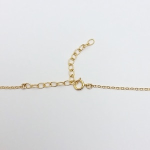 May include: A gold chain necklace with a lobster clasp closure. The chain is made of small, round links.