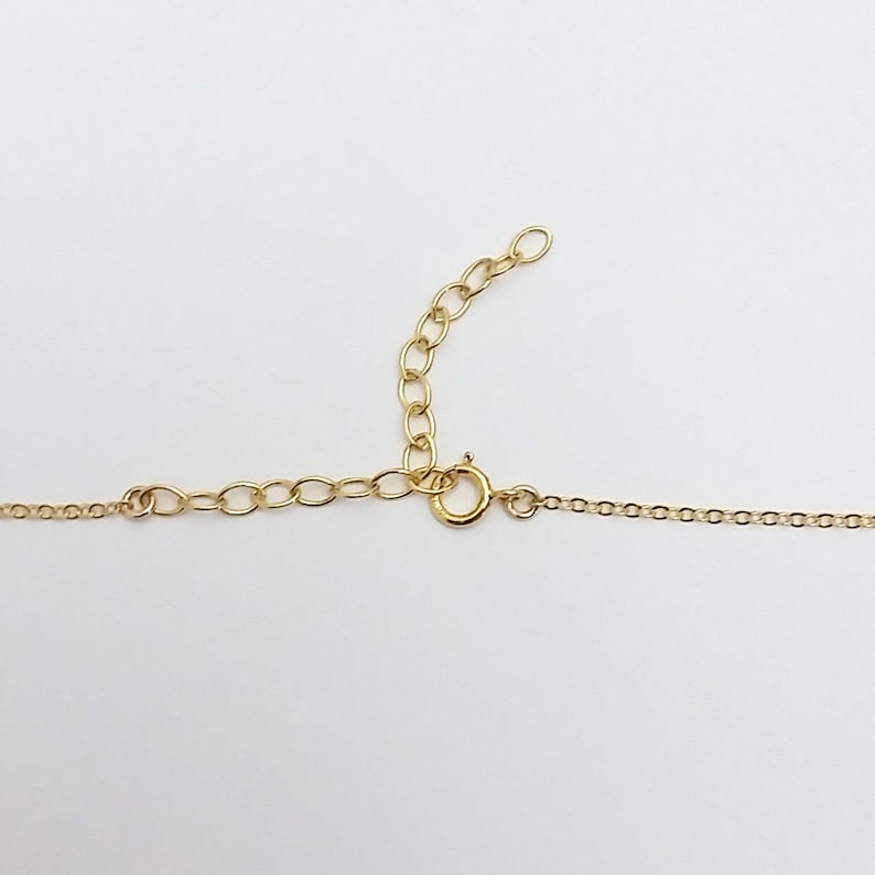 May include: A gold chain necklace with a lobster clasp closure. The chain is made of small, round links.