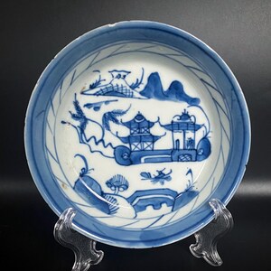 Puede incluir: Un plato de porcelana azul y blanco con un dise&ntilde;o decorativo de un paisaje chino con una pagoda y &aacute;rboles. El plato tiene un fondo blanco con detalles azules y un borde azul.