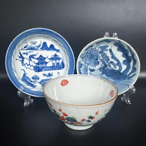 Puede incluir: Tres cuencos de porcelana antiguos con dise&ntilde;os florales y paisaj&iacute;sticos azules y blancos. El cuenco del centro tiene acentos florales rojos y naranjas.