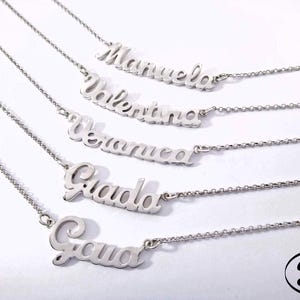 Pode incluir: Cinco colares de prata com nomes personalizados, incluindo "Gabriela", "Guada", "Veronica", "Valentina" e "Manuela".
