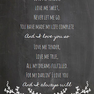 Peut inclure: Un tableau noir avec une inscription &agrave; la craie blanche qui dit "LOVE ME TENDER, LOVE ME SWEET, NEVER LET ME GO. YOU HAVE MADE MY LIFE COMPLETE And I love you so LOVE ME TENDER, LOVE ME TRUE, ALL MY DREAMS FULFILLED. FOR MY DARLIN' I LOVE YOU And I always will". L'&eacute;criture est entour&eacute;e d'un dessin de guirlande florale &agrave; la craie blanche.