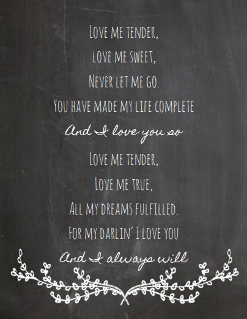 Peut inclure: Un tableau noir avec une inscription &agrave; la craie blanche qui dit "LOVE ME TENDER, LOVE ME SWEET, NEVER LET ME GO. YOU HAVE MADE MY LIFE COMPLETE And I love you so LOVE ME TENDER, LOVE ME TRUE, ALL MY DREAMS FULFILLED. FOR MY DARLIN' I LOVE YOU And I always will". L'&eacute;criture est entour&eacute;e d'un dessin de guirlande florale &agrave; la craie blanche.