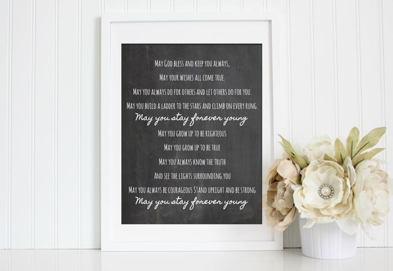 May include: A black and white printable quote on a chalkboard background. The quote reads: "May God bless and keep you always, May your wishes all come true. May you always do for others and let others do for you. May you build a ladder to the stars and climb on every rung. May you stay forever young. May you grow up to be righteous. May you grow up to be true. May you always know the truth and see the lights surrounding you. May you always be courageous stand upright and be strong. May you stay forever young."