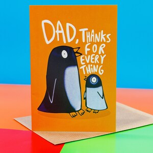 The card is orange with an adult black penguin and baby grey penguin facing each other with text round them reading Dad thanks for everything. Designed by Katie Abey in the UK.