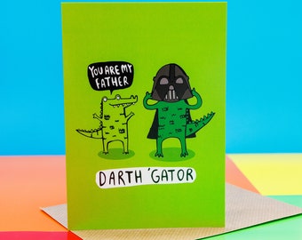 May include: A green card with a cartoon alligator wearing a Darth Vader mask. The card says "You are my father" and "Darth 'Gator".