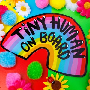 Tiny human on board vinyl car window sticker featuring black text on a rainbow design by Katie Abey laminated and weather proof