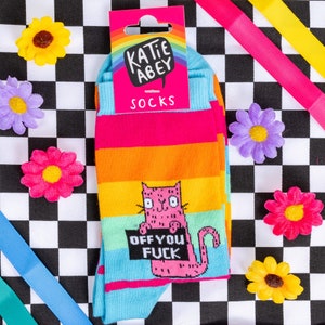 Katie Abey off you fuck socks with pink cat holding a sign. They are rainbow striped and lovely and vibrant.