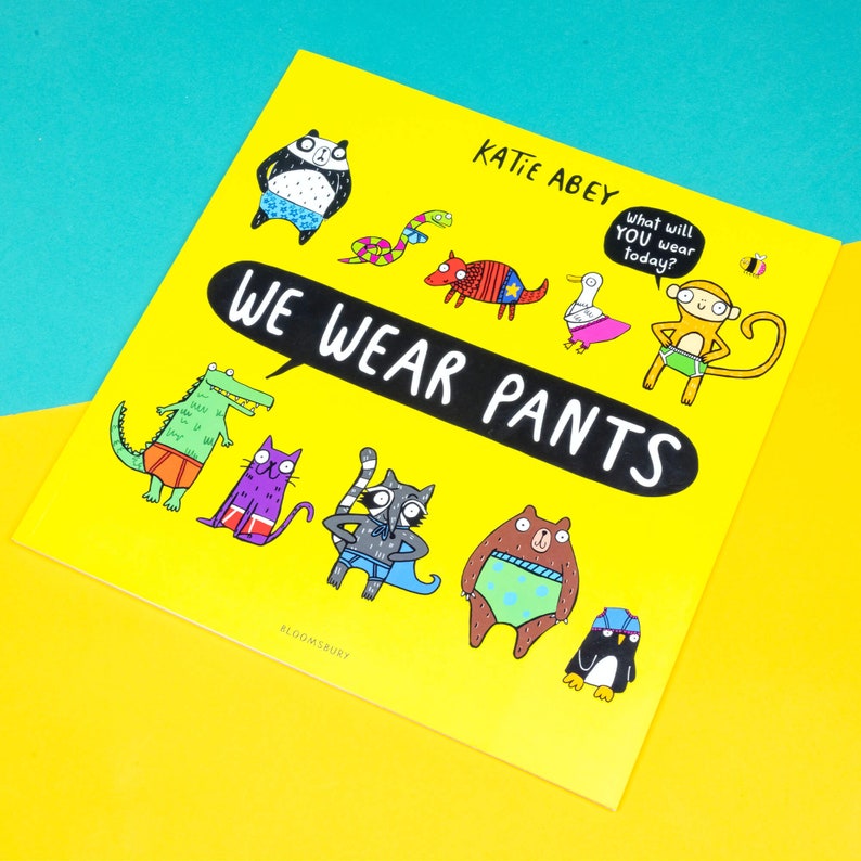 We wear pants book by Katie Abey. The book cover is yellow background with various animals wearing various pants. The centre text inside a speech bubble reads we wear pants