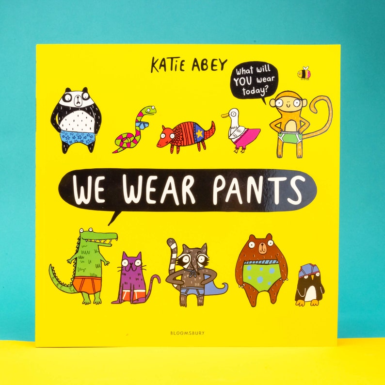 We wear pants book by Katie Abey. The book cover is yellow background with various animals wearing various pants. The centre text inside a speech bubble reads we wear pants