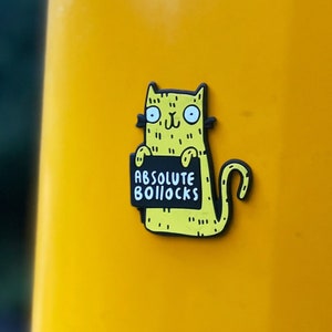 Swear Word Yellow and Black Cat Fridge Magnet holding funny sign. Designed by Katie Abey in the UK